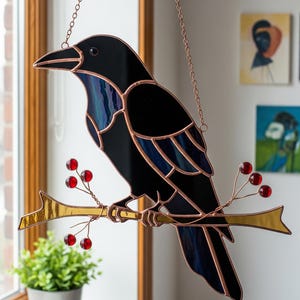 May include: Stained glass raven perched on a golden branch with red berries. The raven is black with blue and purple accents, framed by copper-colored metal. A decorative piece for home decor.