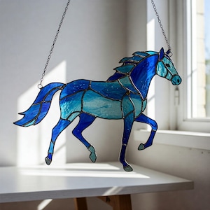May include: A stained glass horse hanging from a chain. The horse is blue and has a white and blue pattern.
