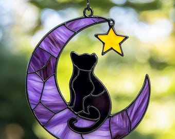 Puede incluir: Un atrapasol de vidrio coloreado con un gato negro sentado en una luna creciente morada con una estrella amarilla arriba.