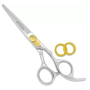 May include: Silver hair cutting shears with a gold accent and a finger rest. The shears have two gold rings.