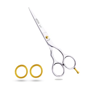 May include: Silver hair cutting shears with gold accents. The shears are 6.5 inches long and have two finger rings. Two gold rings are also shown in the image.