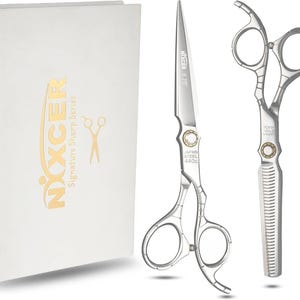 May include: A pair of silver Nixcer 6.75 inch hair cutting shears and a pair of thinning shears with Japan 440c steel markings, presented alongside a white rectangular storage box featuring the Nixcer logo and Signature Sharp Series text.
