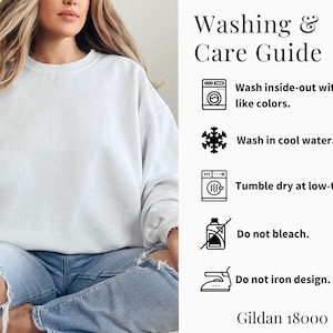 May include: A white sweatshirt with a washing and care guide. The guide includes instructions to wash inside-out with like colors, wash in cool water, tumble dry at low-temp, do not bleach, and do not iron design. The brand is Gildan 18000.