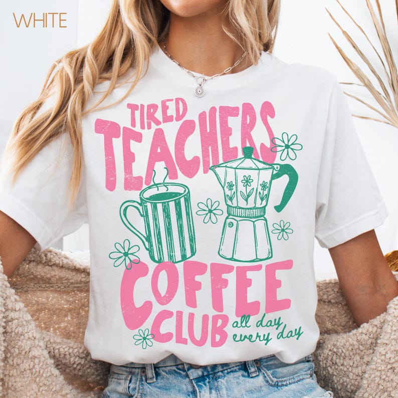 May include: White t-shirt with a pink and green graphic. The graphic reads "Tired Teachers Coffee Club" with images of a coffee mug, a coffee pot, and flowers. The phrase "all day every day" is also included.