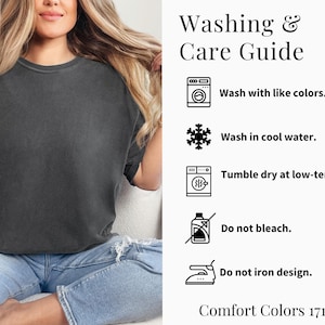 Puede incluir: Una mujer con una camiseta Comfort Colors gris oscuro y vaqueros azul claro. La imagen incluye una "Gu&iacute;a de lavado y cuidado" con instrucciones: lavar con colores similares, lavar en agua fr&iacute;a, secar en secadora a baja temperatura, no usar lej&iacute;a y no planchar el dise&ntilde;o.