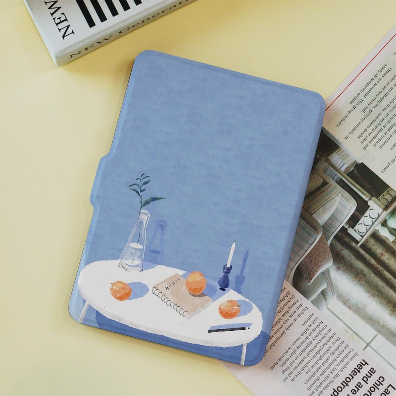 May include: A light blue tablet case featuring a painted illustration of a small white table with oranges, a notebook, a candle, and a vase with a plant. The word "NEW" is visible on a book in the background.