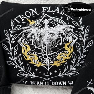 K&ouml;nnte beinhalten: Schwarzer gestickter Patch mit einem wei&szlig;en Ph&ouml;nix-Design und dem Text "IRON FLAME" und "BURN IT DOWN".