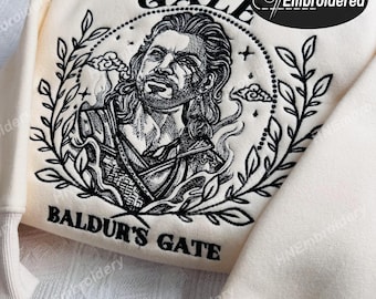 Op de afbeelding: Een wit sweatshirt met zwarte borduursels van een personage uit het videospel Baldur's Gate. De borduursels bevatten de tekst "Gale" en "Baldur's Gate".