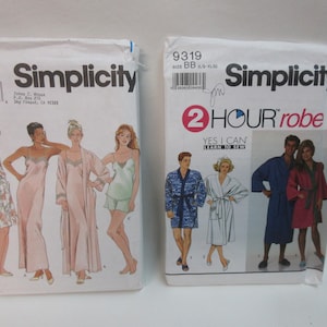 May include: Two sewing pattern envelopes. The left envelope is for a Simplicity pattern number 480 and features a drawing of three women wearing sleepwear. The right envelope is for a Simplicity pattern number 9319 and features a drawing of two couples wearing robes. The text on the right envelope reads "2 HOUR robe YES I CAN LEARN TO SEW".