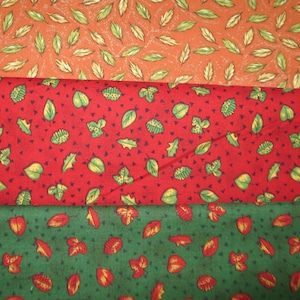 May include: Three fabric swatches with different leaf patterns. The top swatch is orange with green leaves, the middle swatch is red with green leaves, and the bottom swatch is green with orange leaves.