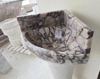 Lavabo de mármol Calacatta Viola con textura acanalada, para montaje en pared.