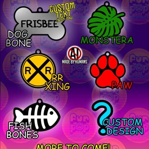 May include: A collection of six pet ID tags featuring various shapes and designs: a silver dog bone, a green monstera leaf, a yellow railroad crossing sign, a red paw print, a black fish skeleton, and a blue question mark with custom design text.