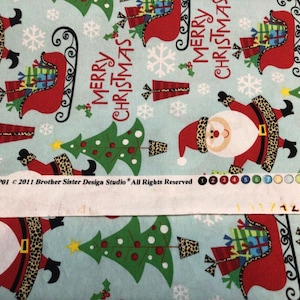 May include: Light blue Christmas-themed fabric with a repeating pattern of Santa Claus figures, Christmas trees, snowflakes, and gift boxes. The words "MERRY CHRISTMAS" are also featured. The Santa Claus figures have leopard print belts and cuffs.