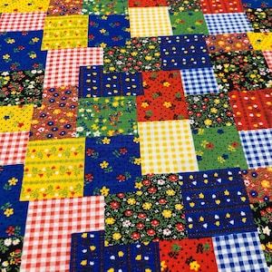May include: A patchwork fabric with a variety of patterns and colors. The squares feature floral prints, gingham checks, and solid colors in red, blue, yellow, and green. The fabric is likely used for quilting or crafting.