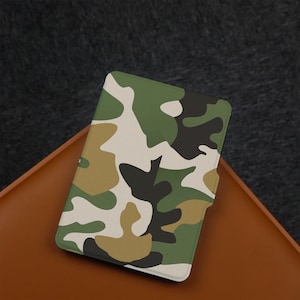 May include: A camouflage patterned e-reader cover with a white, green, and brown design.