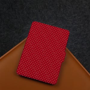 May include: Red e-reader case with a white polka dot pattern.