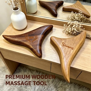 May include: Wooden massage tools in various shades of brown. One tool is engraved with the name "Simon", and another with a deer antler design. The tools are displayed on a wooden surface with the text "PREMIUM WOODEN MASSAGE TOOL".