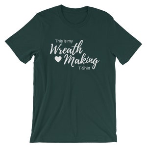 May include: A dark green t-shirt with the text "This is my Wreath Making T-Shirt" in white lettering with a white heart.