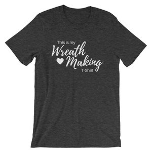 May include: A dark heather grey t-shirt with the text "This is my Wreath Making T-Shirt" in white lettering with a white heart.