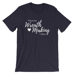 May include: Navy blue t-shirt with white text that reads "This is my Wreath Making T-Shirt" with a white heart symbol.