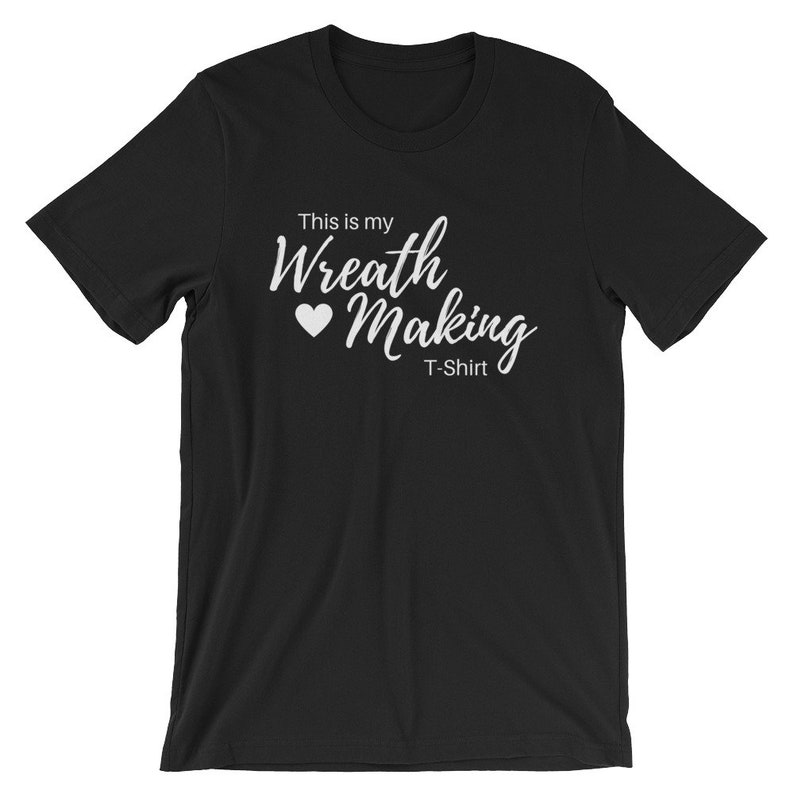 May include: Black t-shirt with white text that reads "This is my Wreath Making T-Shirt" with a white heart symbol.