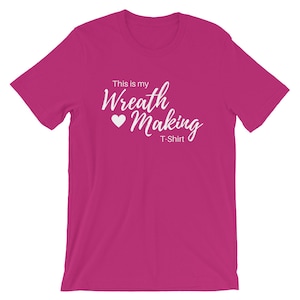 May include: A pink t-shirt with the text "This is my Wreath Making T-Shirt" in white with a white heart.