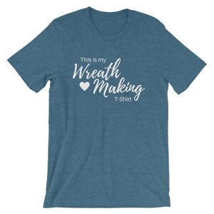 May include: A teal blue t-shirt with the text "This is my Wreath Making T-Shirt" in white lettering with a white heart.