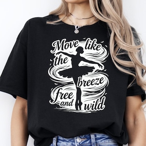May include: Black t-shirt with a white graphic of a ballerina and the words "Move like the breeze free and wild". The design features a ballerina in a tutu with swirling lines around her.