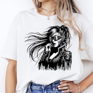 May include: White t-shirt featuring a black and white graphic of a futuristic woman with long flowing hair, wearing high-tech eyewear and a jacket. The design has a cyberpunk aesthetic, with detailed mechanical elements.