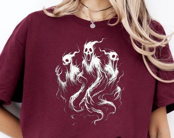 Op de afbeelding: Een bordeauxrood t-shirt met een witte afbeelding van drie gestileerde geesten met open monden en klauwachtige handen. De spookachtige figuren hebben een spookachtig, etherisch uiterlijk. Het shirt is een casual, ronde hals stijl.