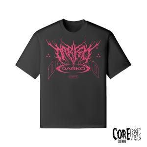 Puede incluir: Camiseta negra con un diseño gráfico rosa. El diseño presenta la palabra "DARKO" en una fuente estilizada, con texto adicional y acentos de estrellas. La camiseta es de la marca "COREPSE CLOTHING".