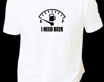 Op de afbeelding: Wit T-shirt met een zwarte afbeelding van een biermeter, de naald wijst naar vol. De tekst "I NEED BEER" staat eronder. Het shirt is gemaakt van een zacht materiaal.