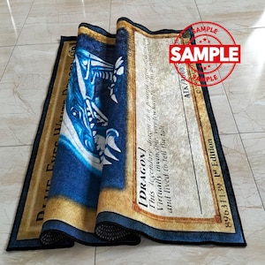 Może przedstawiać: Zwinięty dywan z niebiesko-białym wzorem smoka i napisem "Blue Eyes White Dragon". Dywan ma złotą obw&oacute;dkę, a słowo "SAMPLE" jest wytłoczone w prawym g&oacute;rnym rogu.