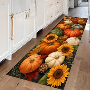 Könnte beinhalten: Ein rechteckiger Küchenläufer mit einem herbstlichen Erntedesign. Der Teppich zeigt Kürbisse, Sonnenblumen und Herbstlaub in Orange, Gelb, Grün und Rot auf dunklem Hintergrund.