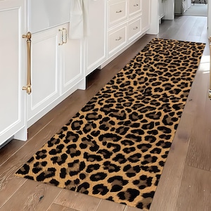 Könnte beinhalten: Ein langer, rechteckiger Teppich mit Leopardenmuster, beigem Hintergrund und schwarzen und braunen Flecken. Der Teppich liegt auf einem Holzboden in einer Küche oder einem Flur. Der Teppich verleiht dem Raum einen Hauch von Animal-Print-Stil.