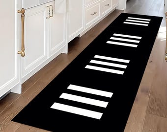 May include: Black and white striped runner rug with a modern design. The rug is placed on a wooden floor in a hallway.