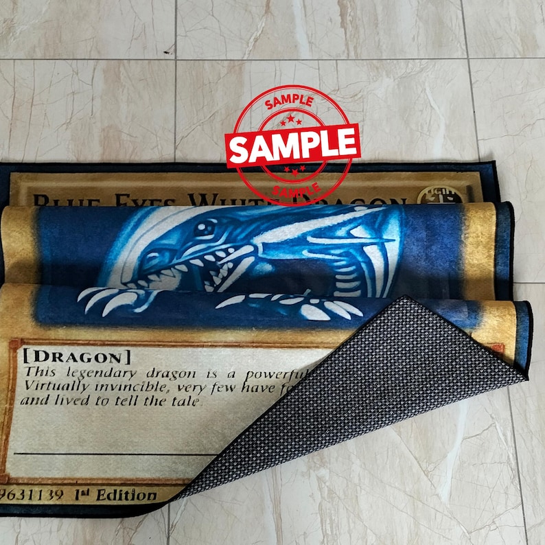 Może przedstawiać: Prostokątny dywan z niebiesko-białym wzorem smoka i napisem "BLUE EYES WHITE DRAGON". Dywan ma czarną obw&oacute;dkę i antypoślizgowy sp&oacute;d. Na dywanie znajduje się stempel z napisem "SAMPLE".