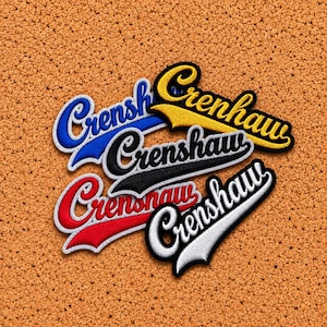 Puede incluir: Una colección de cinco parches bordados con la palabra Crenshaw en una fuente cursiva. Los parches están superpuestos y vienen en azul, amarillo, negro, rojo y blanco, cada uno con un contorno contrastante y una cola que se extiende a la derecha.