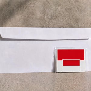 May include: A white rectangular envelope positioned next to a small, clear plastic sleeve containing two stacked rectangular stickers. Each sticker features a horizontal bicolored design with a solid red top half and a white bottom half.