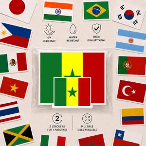 May include: A set of two vinyl stickers featuring the flag of Senegal, which consists of vertical green, yellow, and red stripes with a green star in the centre. The stickers are packaged in a clear plastic sleeve, surrounded by various other national flag stickers.