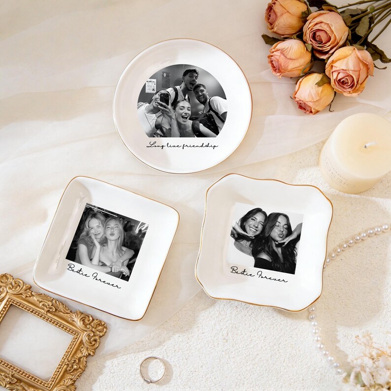K&ouml;nnte beinhalten: Drei wei&szlig;e Keramikschalen mit goldenem Rand, jeweils mit einem Schwarz-Wei&szlig;-Foto. Eine ist rund mit dem Text "Long live friendship", und zwei sind quadratisch mit dem Text "Bestie Forever".