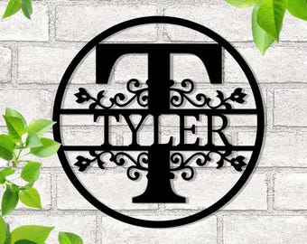 Peut inclure: Cercle en métal noir avec une grande lettre T et le nom Tyler dans une police décorative. Le cercle a une bordure décorative avec des accents floraux.