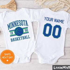 May include: Two white baby onesies. One onesie has the text "Minnesota Basketball" with a basketball graphic and the numbers "19" and "90". The other onesie has the text "Your Name" and the number "00".