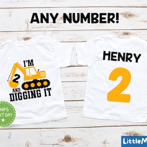 May include: Two white t-shirts with a construction theme. One shirt has a yellow excavator with the text "I'm 2 and digging it". The other shirt has the name "Henry" and the number "2" in yellow.