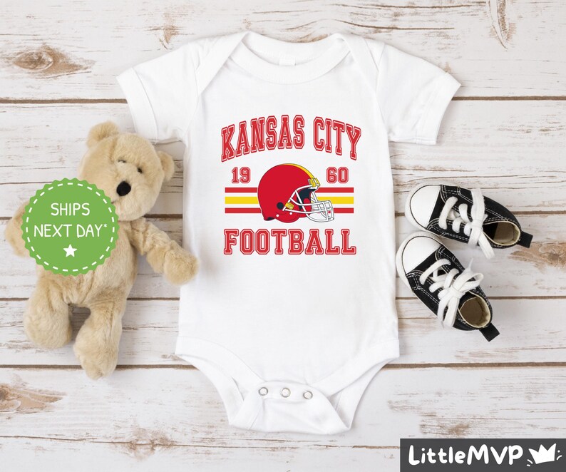 a teddy bear sitting next to a kansas city football shirt