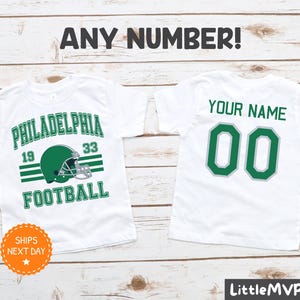 a pair of personalized football shirts on a wooden background
