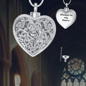 May include: Silver heart-shaped cremation pendant with a delicate floral design and the inscription "Always in my heart". The pendant comes with a small funnel for filling.