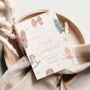 Könnte beinhalten: Eine hellrosa Einladungskarte mit dem Text "OLIVIA'S Winter Onederland". Die Karte zeigt Illustrationen eines Nussknackers, eines Schaukelpferds, einer Ballerina, eines Geschenks, einer Schleife, eines Weihnachtsbaums und Schneeflocken. Die Einladung liegt auf einem Holztablett.