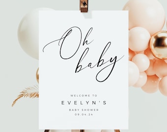 Op de afbeelding: Een wit bord met zwarte kalligrafie waarop "Oh baby" staat en de tekst "Welkom op Evelyn's Baby Shower 09.04.24".