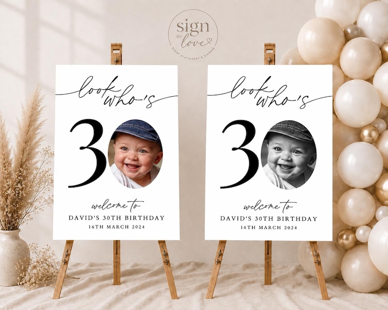 May include: Two identical white rectangular birthday signs on wooden easels. Each sign features the black text 'look who's 30', a large black number '30', a circular photo of a smiling baby in a cap, and the text 'welcome to DAVID'S 30TH BIRTHDAY 16TH MARCH 2024'.
